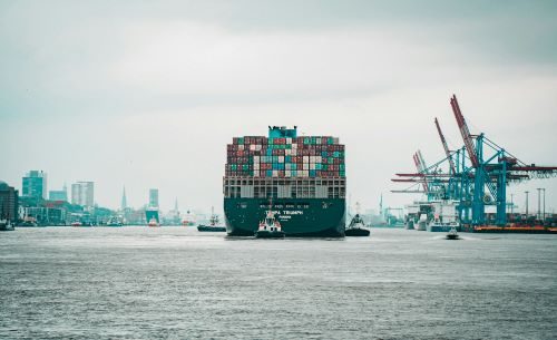 A ship full of containers sailing off from port.