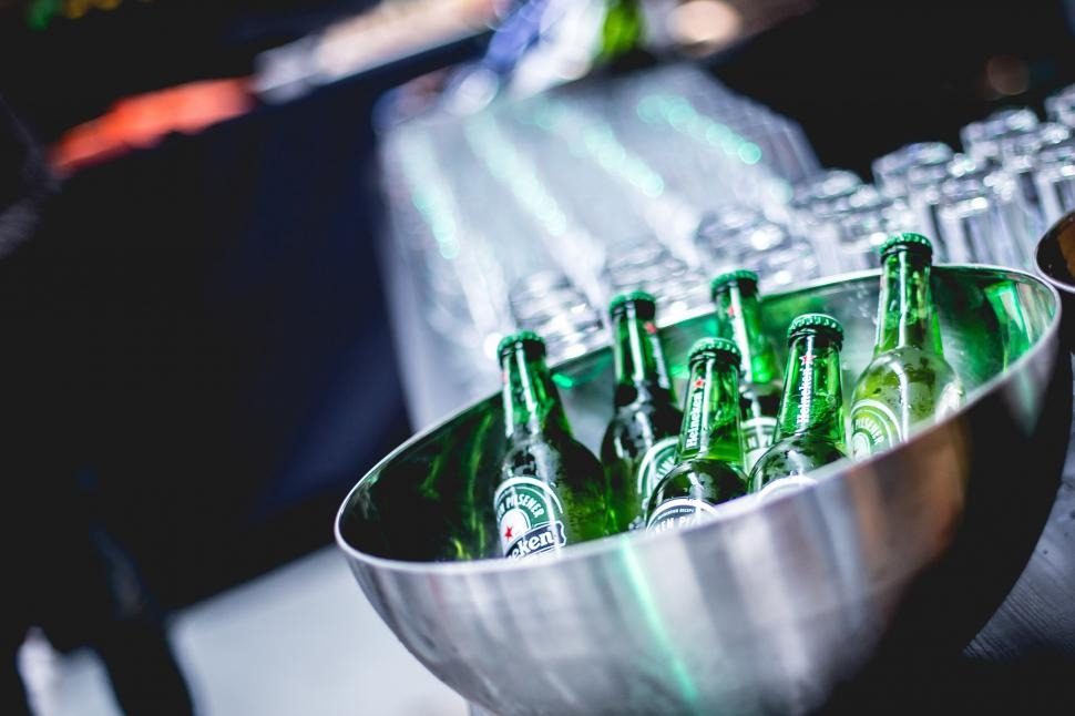 An arrangement of ice-cold Heineken beers in a sustainable sourced bowl, showcasing environmentally responsible enjoyment