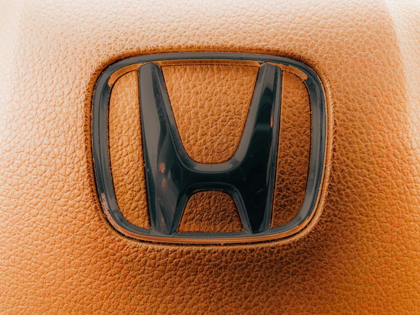 The honda logo set on a brown leather surface.