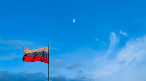Russian flag flying against a blue sky.