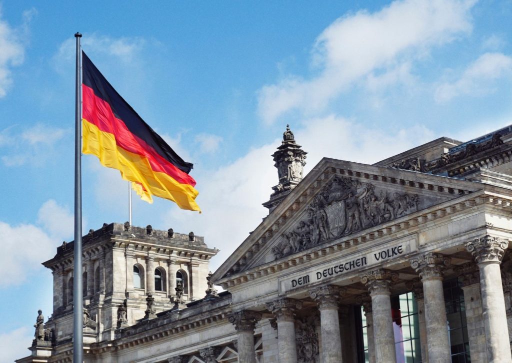 An image of the german flag flying over government buildings.