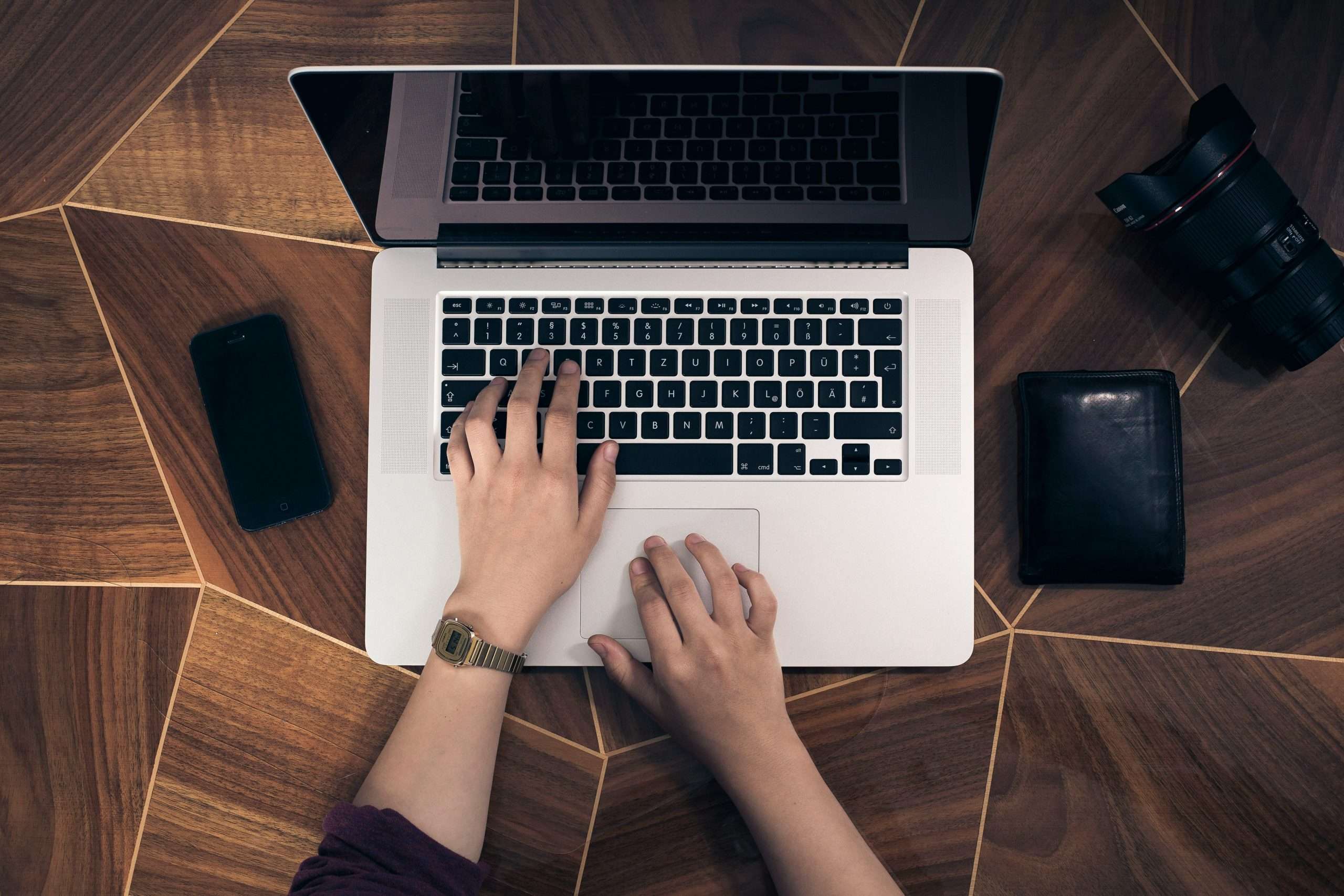 A laptop open on a table with person typing into a supply chain erp system.