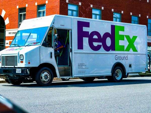 A FedEx truck driving down a street in North America.