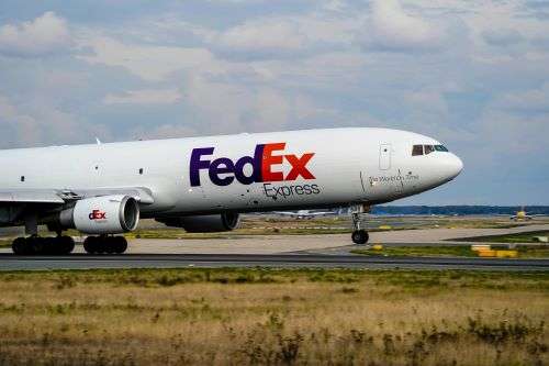 A FedEx cargo plane taking off from an airport runway.