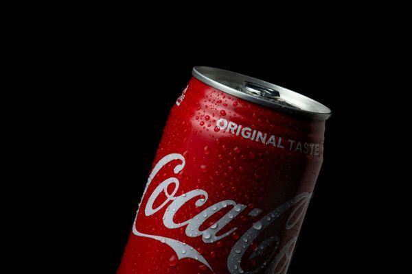 A can of Coca-Cola against a black backdrop.