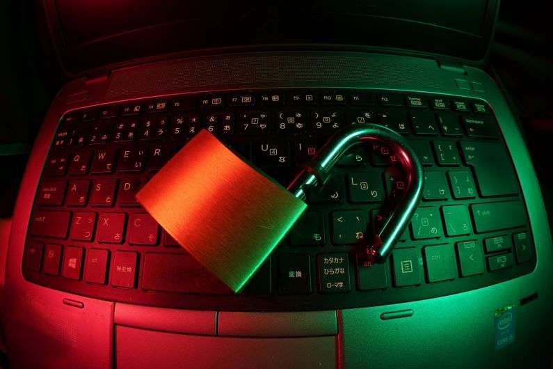 An open padlock sitting on a laptop keyboard representing cyber crime.