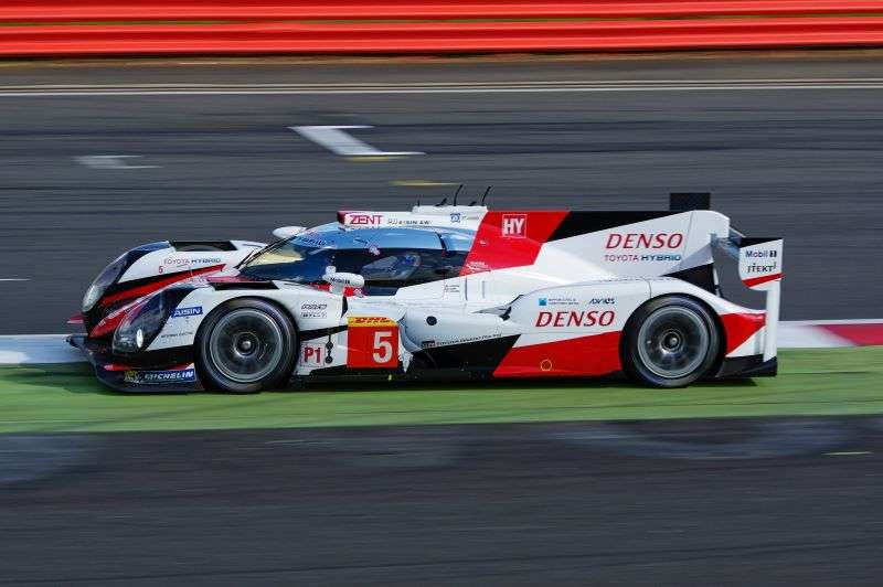 A Denso car racing on a race track.