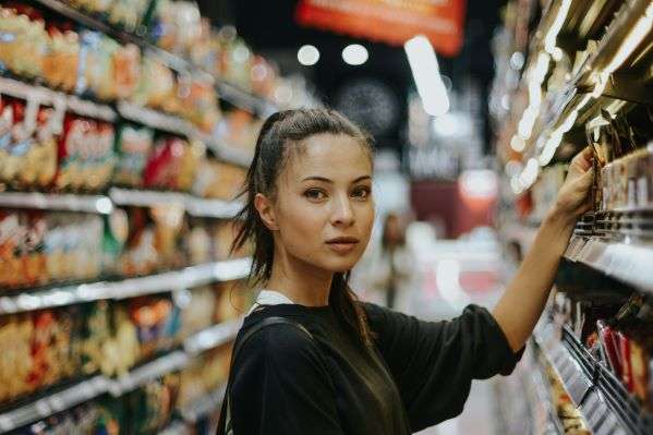 A lady lifting a product from the shelf in a Dollar General store.