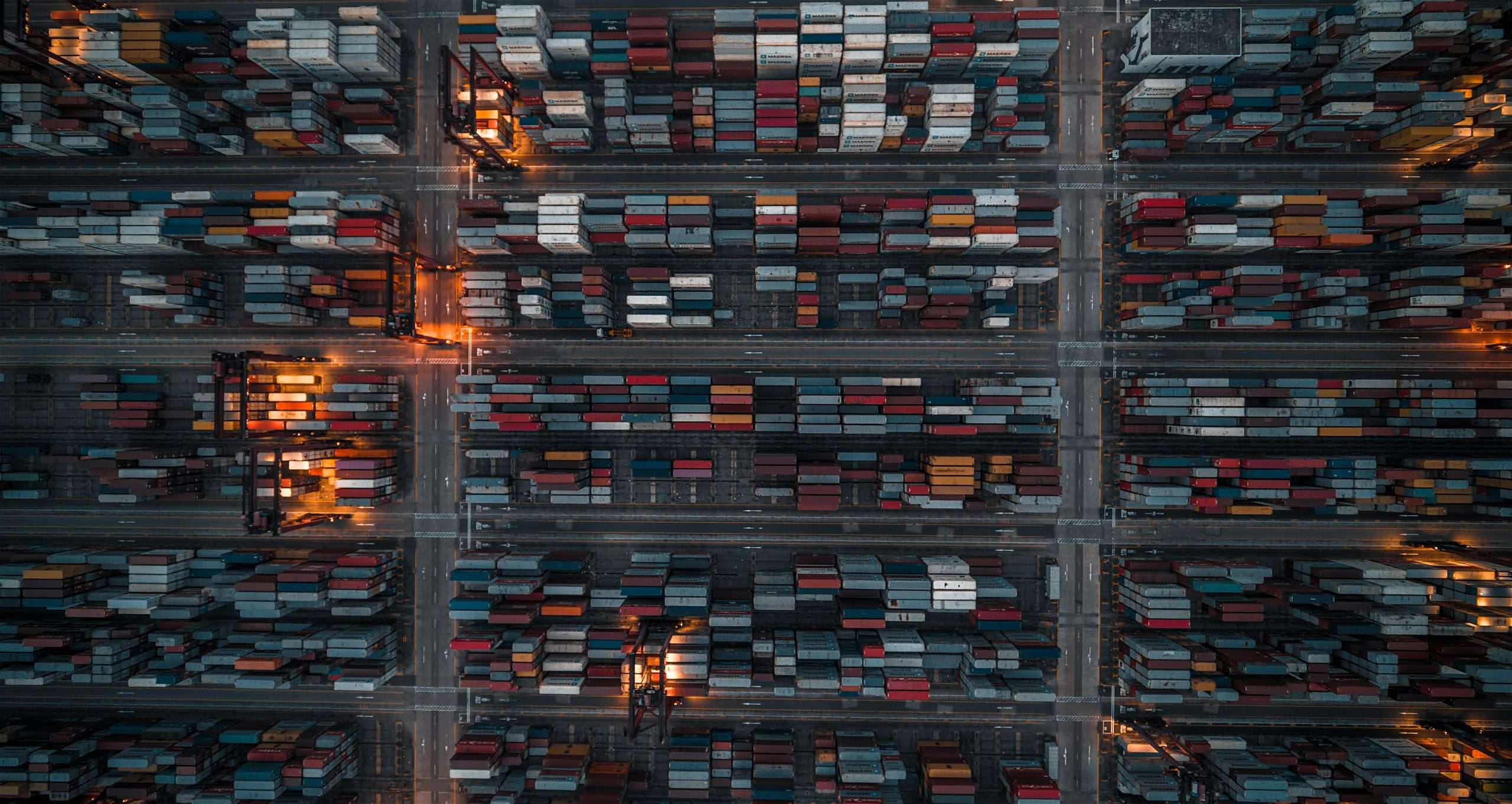 A birds eye view of a shipping yard, full of containers.