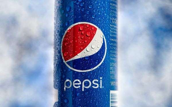 A can of Pepsi within a fridge with ice.