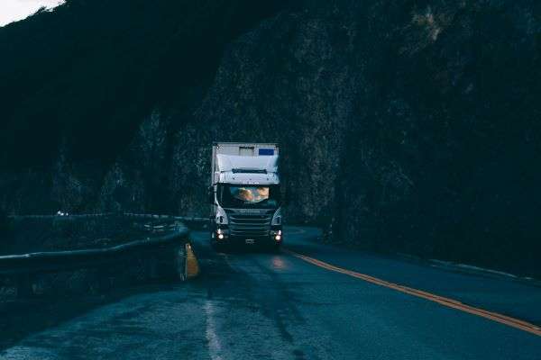 An image of a freight truck emerging from a dark tunnel.