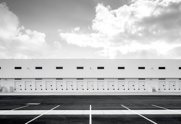 An external view of a warehouse in black and white.