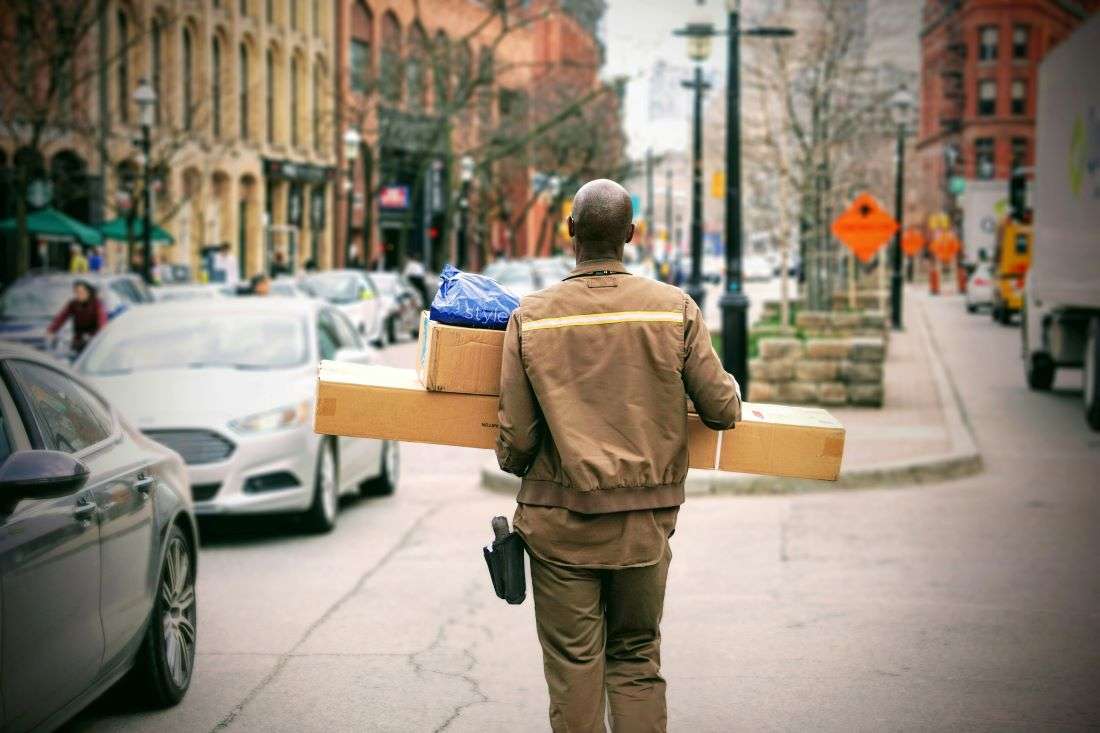 A delivery driver carrying an international package. The global e-commerce landscape is facing a significant challenge. According to a survey by Avalara, 58% of consumers who purchase goods internationally have encountered unexpected customs charges upon delivery.