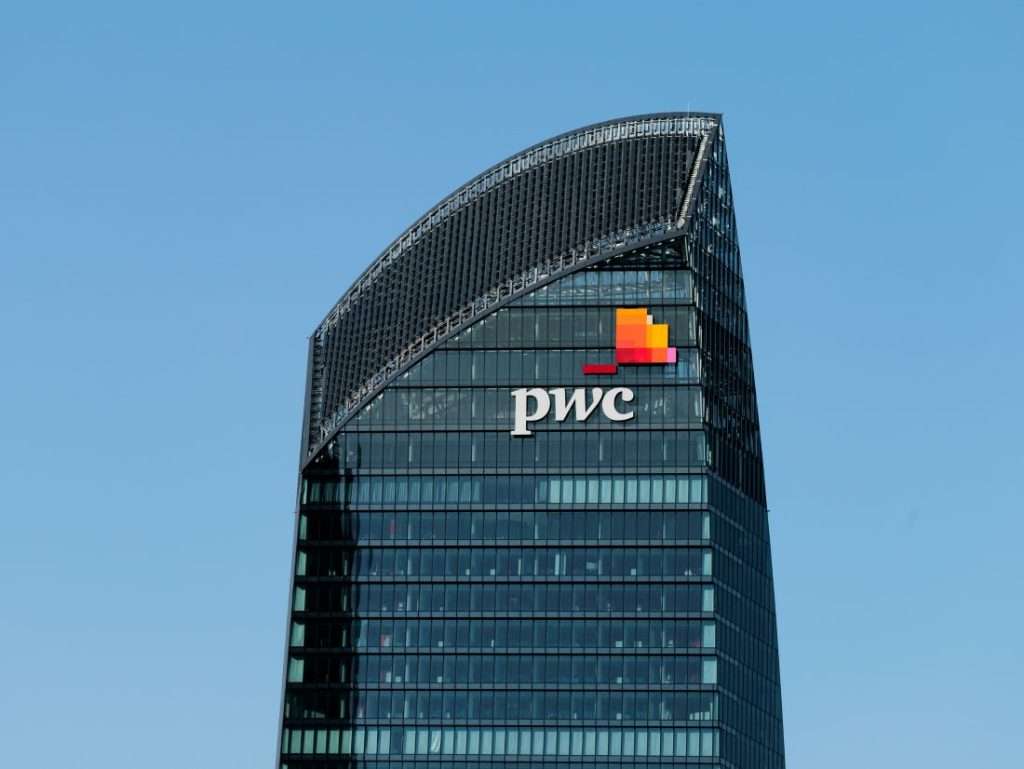 A PwC office seen against a blue sky background.