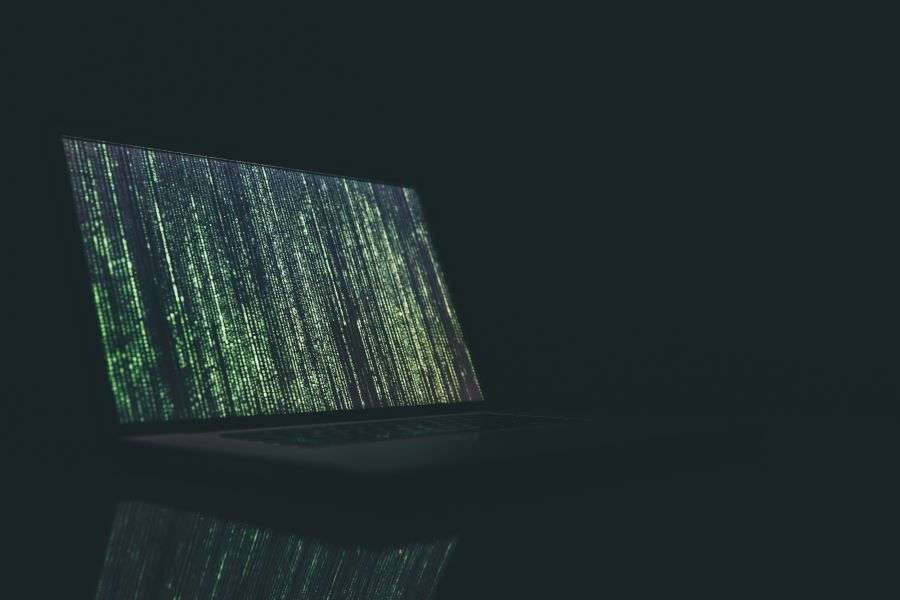 A laptop showing rows of data against a dark and ominous background.