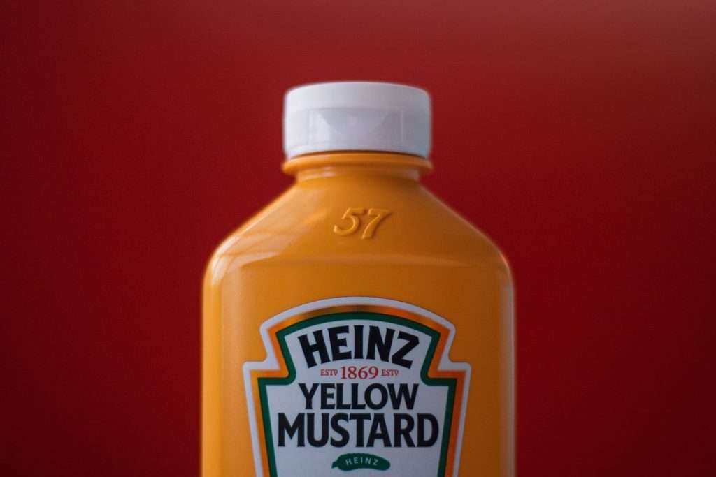 A bottle of Kraft Heinz mustard. Kraft Heinz employs AI-driven 'Lighthouse' to predict demand, steering towards an autonomous supply chain.