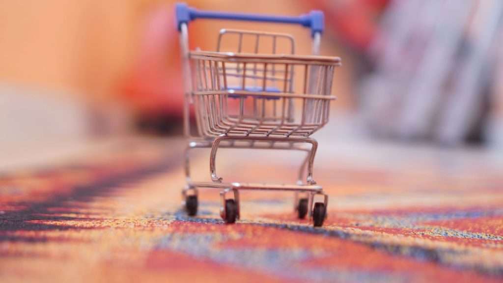 A toy shopping cart on a carpet in a home. Supply chains adapt to e-commerce surge with ecosystem integration, enhancing efficiency.